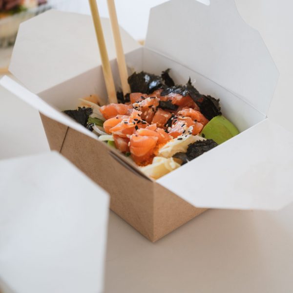 Vertical banner with unrecognizable man eating poke bowl with salmon,seaweed,avocado etc . High quality photo